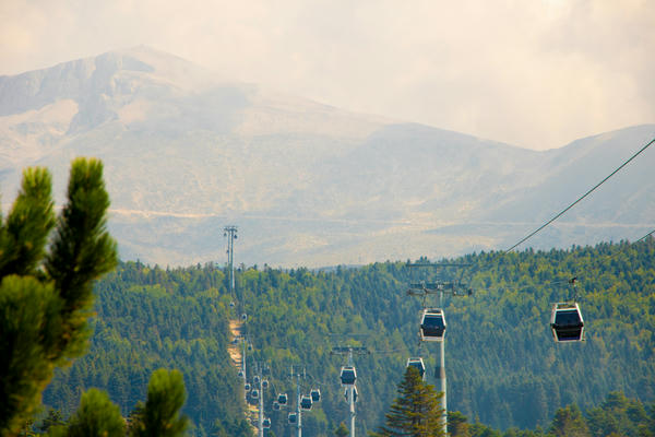 Picture of ropecars with a mountain in the background.