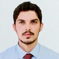 Yiğit Yüksel'in, takım elbise ve kravat giymiş genç bir adamın fotoğrafı.